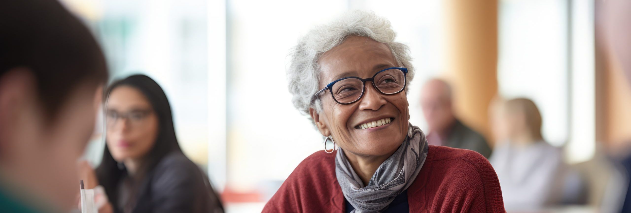 Editorial Photography | EMOTION: Inclusion | SCENE: A frontal shot capturing the warmth and camaraderie of an elderly student participating in a group study session with younger peers in a university common area during the late afternoon | TAGS: 32k, Sony A7III, 35mm lens, f/2.5 aperture, detailed expressions, shallow depth of field, inclusive shading photography, collaborative composition shot, warm color grading, natural lighting, vibrant atmosphere, 2023, lifestyle style, contemporary materials, diverse textures, eclectic color palette, university common area, laptops and textbooks, ISO 320 --ar 3:2 --style raw --stylize 50 --v 5.2 Job ID: 71f3a17a-f5bf-4c47-87b0-3ac7cefade8e